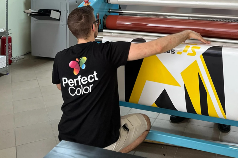 Pracownik montujący grafikę na materiale wielkoformatowym